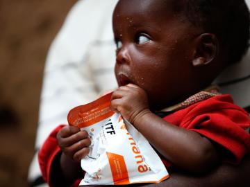 Un niño de Ruanda con un paquete de comida nutricional