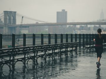 Una chica corre en un día de lluvia