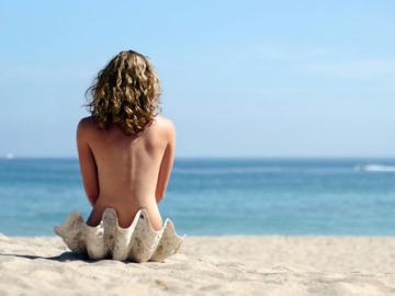 Una joven nudista en una playa Una joven nudista en una playa