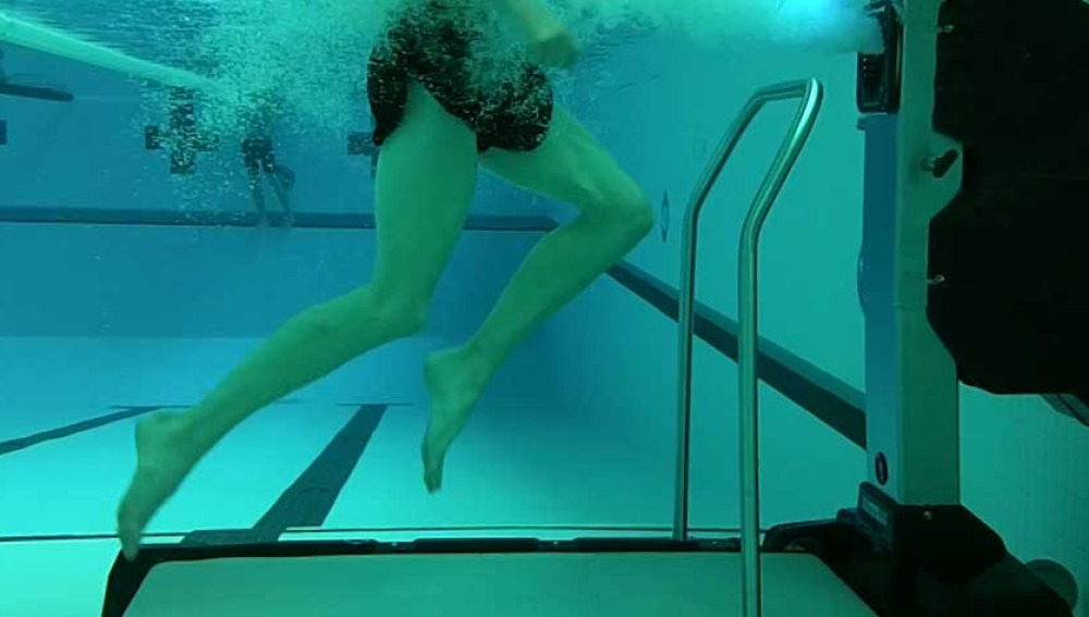 Deportista corriendo sobre una cinta acuática