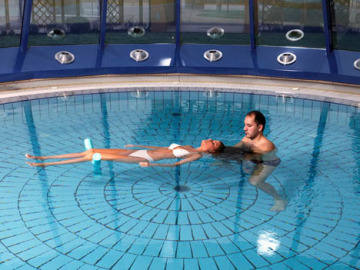 Una mujer practica Watsu en la piscina