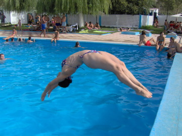 Una mujer se tira de espaldas a una piscina Una mujer se tira de espaldas a una piscina