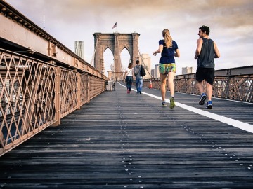 Una pareja corre sobre un puente