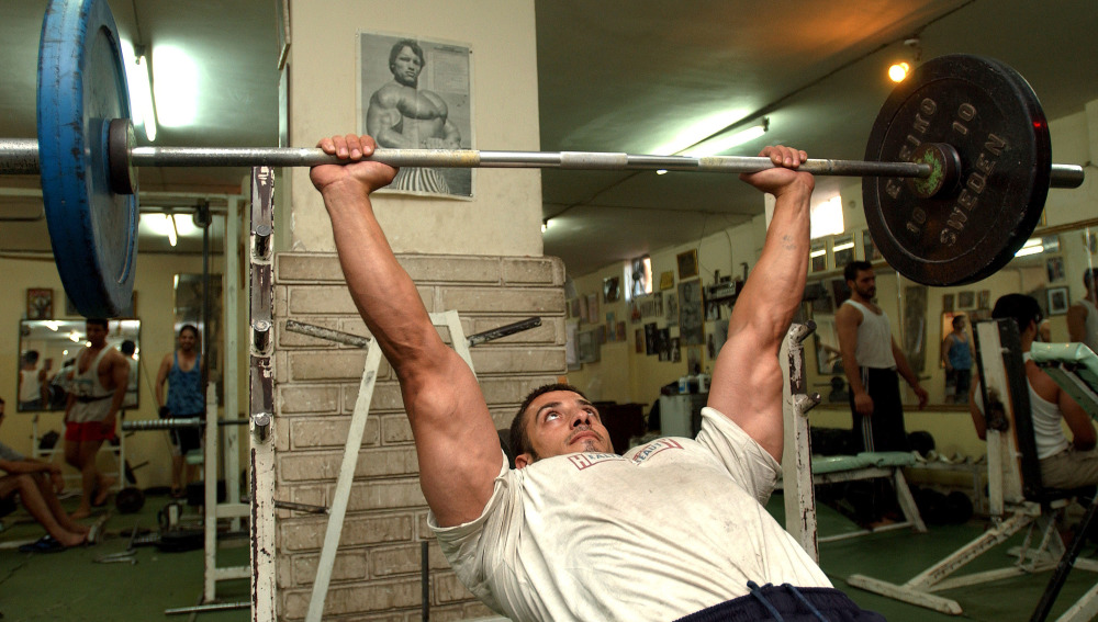 Un hombre trabaja con pesas en el gimnasio