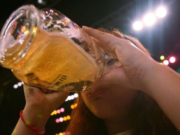 Una mujer bebe una cerveza Una mujer bebe una cerveza