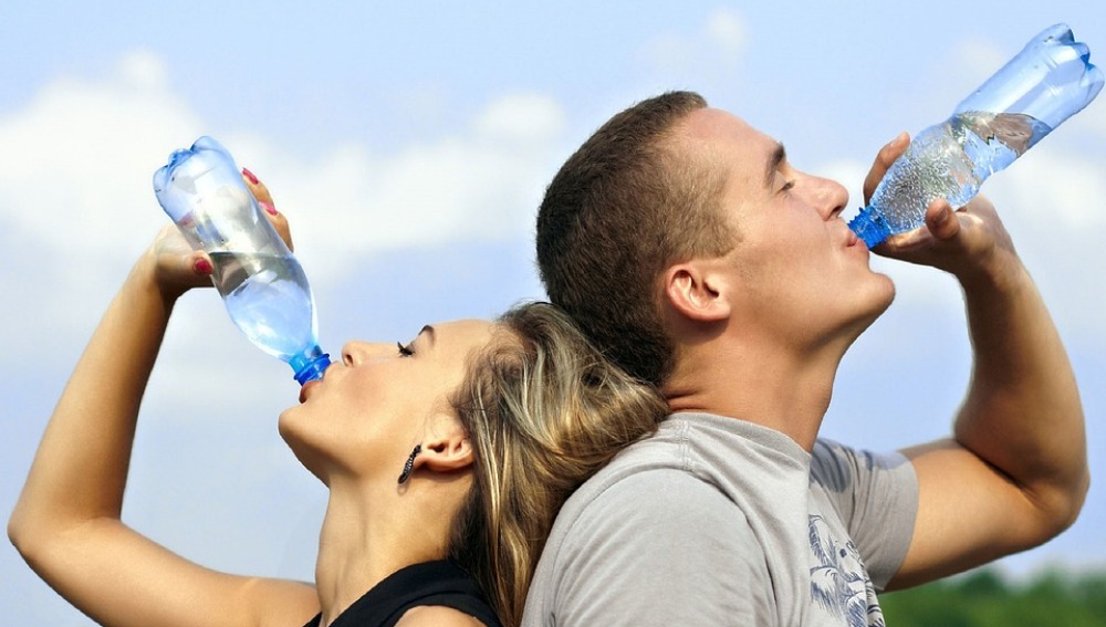 Una pareja bebe agua para hidratarse